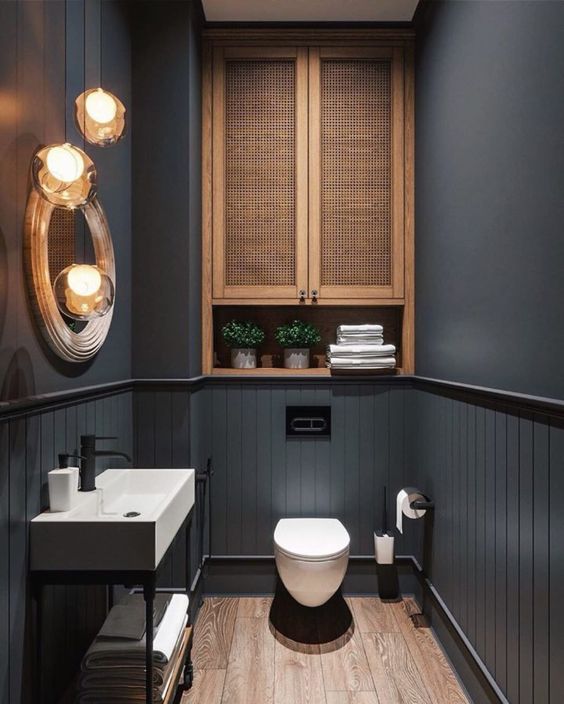 dark gray powder room with wooden and gold accents